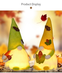 Detail of warm LED glowing gnomes with autumn maple leaf and acorn decorations