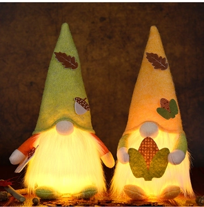 Detail of light-up harvest gnomes with warm glowing beards and fall leaf decorations