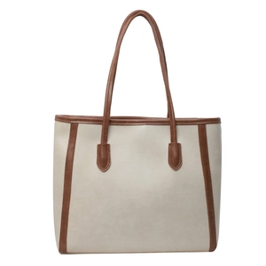 Minimalist beige and brown contrasting leather tote bag for women in a clean studio shot