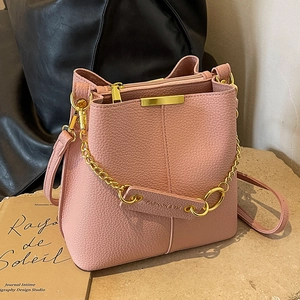 Pink lychee grain leather bucket bag with gold chain and vertical stitching detail
