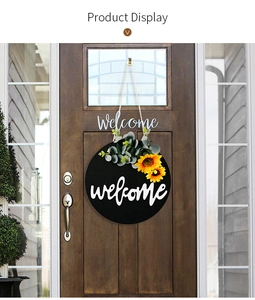Detail of wooden welcome door sign with sunflowers and greenery on dark wood door