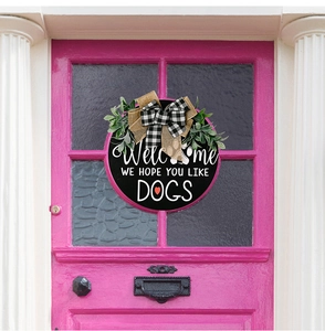 Close-up of rustic wooden dog welcome sign with burlap bow and greenery on pink door