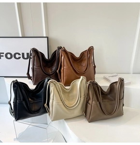 Vista de detalle de bolsos hobo grandes de cuero suave en cinco colores con asas anchas