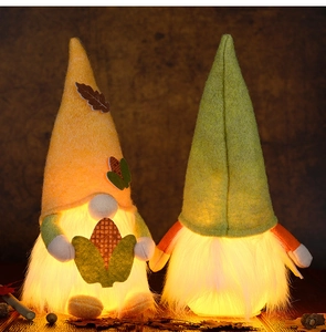 Close-up of LED glowing fall gnomes with maple leaf felt hats for harvest decoration