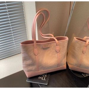 Close-up of pink tote bag showing marble canvas texture and leather handles in sunlight