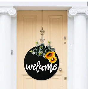 Detail of sunflower and eucalyptus decor on a black wooden welcome door sign
