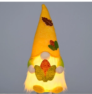Detail of harvest gnome figurine with warm LED glowing beard and maple leaf hat