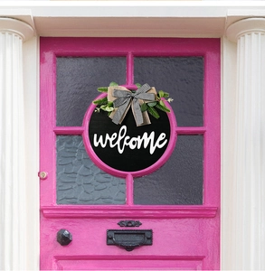 Detail of rustic Welcome door sign with sunflower bow on a decorative pink door