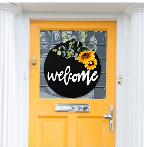 Close-up of a welcome door sign with sunflowers on a bright yellow wooden door
