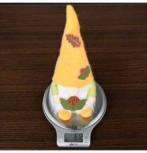Close-up showing a harvest gnome plush weight of 61.2g on an electronic scale
