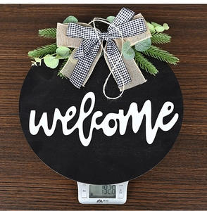 Weight measurement of rustic wooden welcome sign with sunflower bow and greenery detail