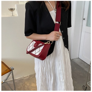 Details der rot-weißen Stepptasche mit breitem Gurt an einem Modell-Outfit