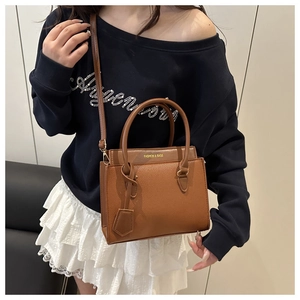 Detailed macro view of brown lychee grain texture and gold FASHION & BAGS logo