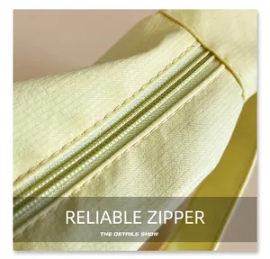 Close-up of smooth color-matched zipper detail on yellow canvas tote shoulder bag