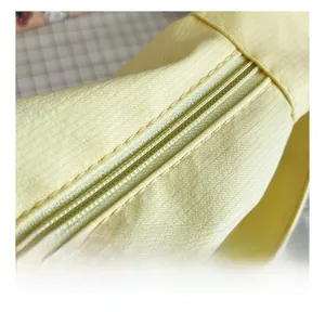 Close-up of smooth color-matched zipper detail on yellow canvas tote shoulder bag