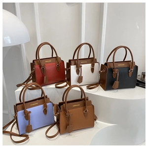 Detailed view of color-block tote bags in various colors on minimalist geometric stands