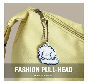 Detail of yellow canvas tote bag featuring silver metal zipper and cute cartoon charm