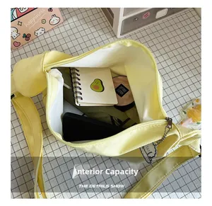 Detail showing high capacity canvas tote bag with notebook, phone and cloud charm