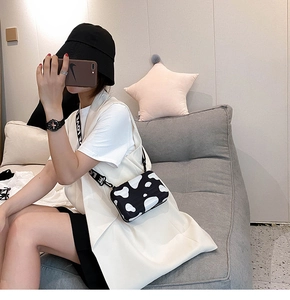 Mini cow print hard shell crossbody bag featuring vertical grooves and LOVE strap