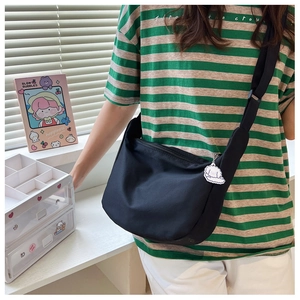 Detail of black canvas tote bag with adjustable strap and cute dog pendant accessory