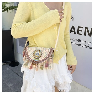 Detail of woven straw crossbody bag with colorful tassels and beadwork for beach