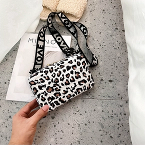 Detailed top view of leopard print hard-shell box bag with LOVE lettered wide strap
