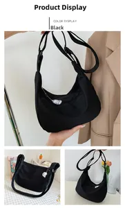 Detail view of a black crescent nylon shoulder bag with a white cartoon charm accessory