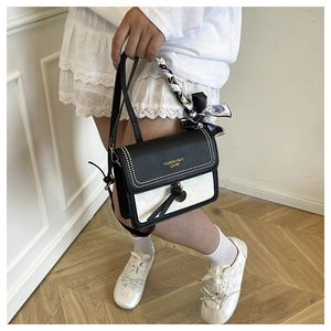 Détail du sac à bandoulière avec design contrasté noir et blanc et poignée en soie