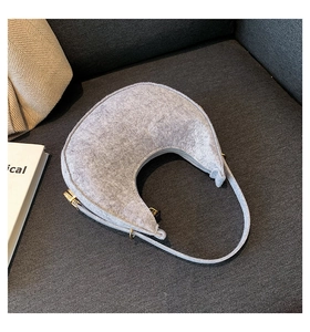 Detailed view of light gray felt hobo bag with zip closure and gold-tone metal hardware