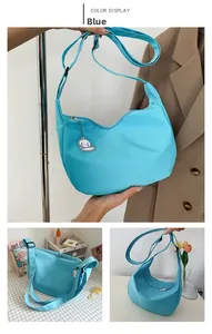 Detail of blue canvas hobo bag with adjustable strap and cute sheep pendant charm