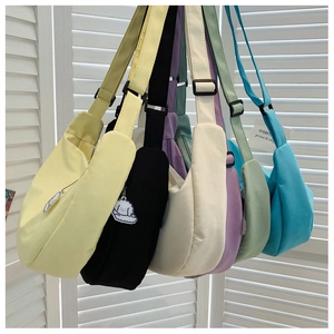 Nylon dumpling bags in five colors with adjustable straps and plush puppy charms