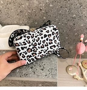 Detail of leopard print mini box bag with wide logo strap and gold dual zippers