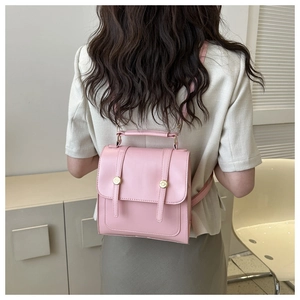 Détail de mini sac à dos rose en similicuir avec boucles à rivets dorés élégants