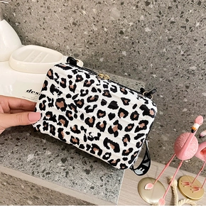 Detail view of mini suitcase bag with leopard print, gold zipper, and adjustable strap