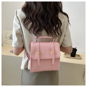 Mini sac à dos rose en similicuir porté par un mannequin dans un décor intérieur