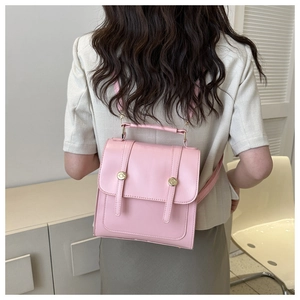 Petit sac à dos rose pour femme porté par un mannequin avec une boucle métallique élégante