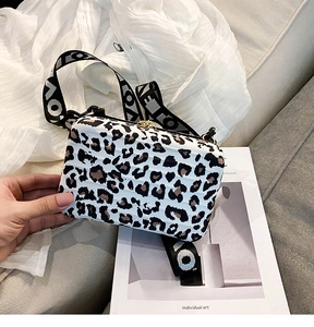 Detail of hardshell mini suitcase bag with leopard print and black wide LOVE strap