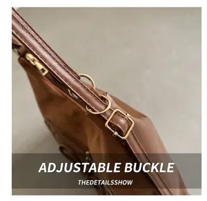 Gros plan sur la boucle en cuir marron foncé et la texture du sac à bandoulière