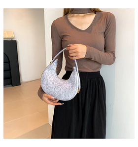 Detail of grey felt hobo bag showing snowflake texture and gold metal buckle hardware