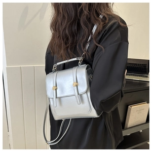 Détail d'un sac bandoulière argenté avec boucle dorée dans un décor de style de vie