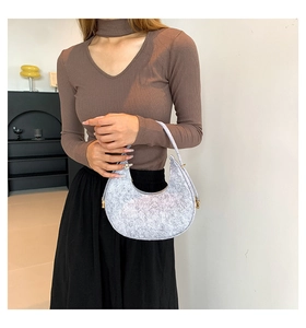 Close-up of embossed silver felt hobo bag with luxury gold ring hardware details
