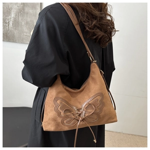 Vue détaillée du sac à bandoulière en cuir mat marron avec nœuds décoratifs de style vintage