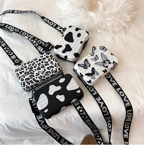 Mini suitcase crossbody bags with butterfly and animal prints on a soft white background