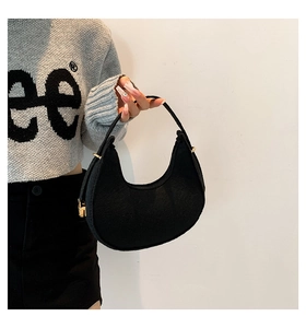 Detail of black felt hobo bag with a golden zipper and textured crescent moon design