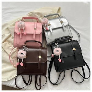 Vue de dessus de mini sacs à dos en quatre couleurs avec rabat et breloques en peluche