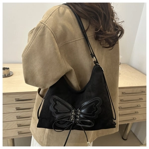 Détail du sac hobo noir avec applique papillon en cuir et design de nœud à lacets raffiné