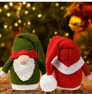 Detail view of two handmade knitted Christmas gnomes with red and green wool textures