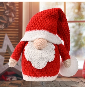 Macro detail of knitted Christmas gnome with white beard and classic red knit texture