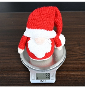 Kitchen scale showing the precise weight of a red knitted Christmas gnome at 119.8g