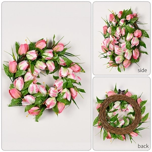 Detail view of pink tulip wreath with green leaves on a natural rattan base frame